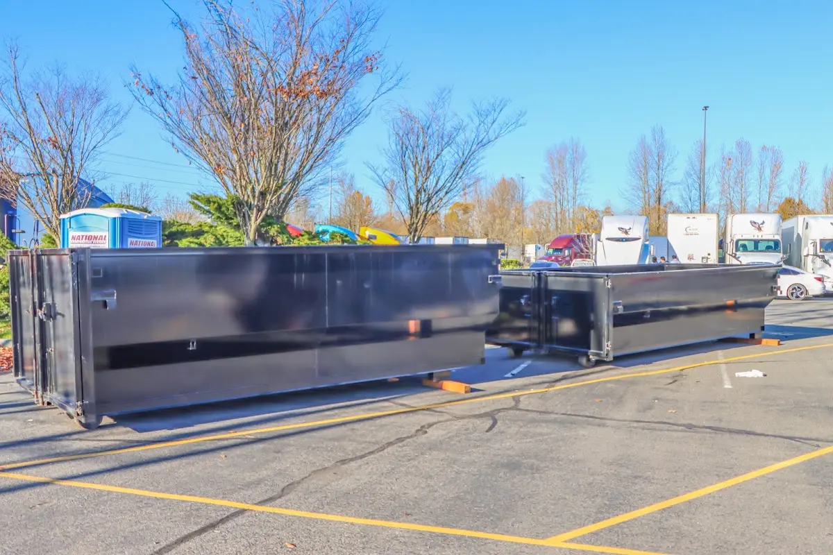 Professional dumpster rental service with roll-off container on residential driveway in Farmington